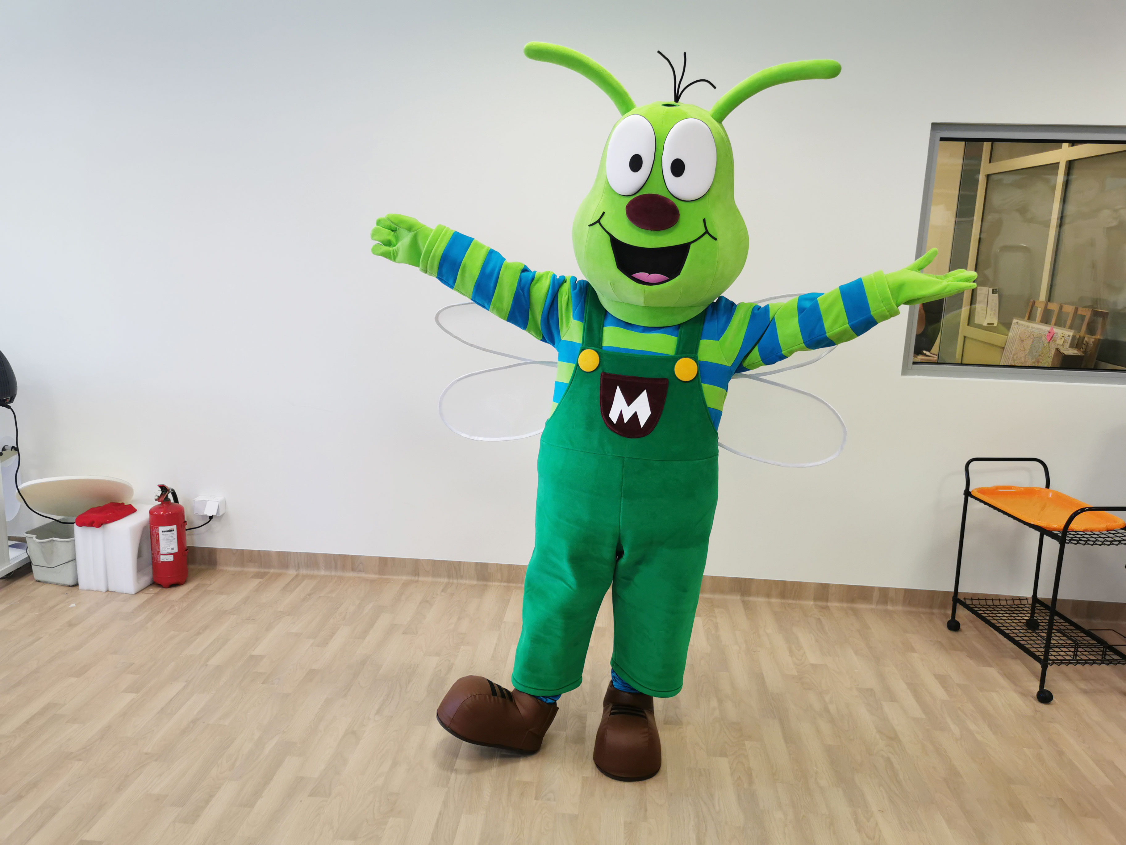 Na fotografii widnieje kostium reklamowy w postaci ważki pozujący do zdjęcia w siedzibie firmy Elabika